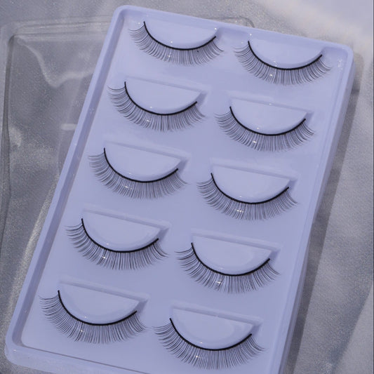 Five pairs of practice lashes for mannequin lash extension training in a white tray.