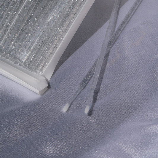 Close-up of fine-tipped micro wands with clear glitter handles beside Wink Supplies AU packaging.